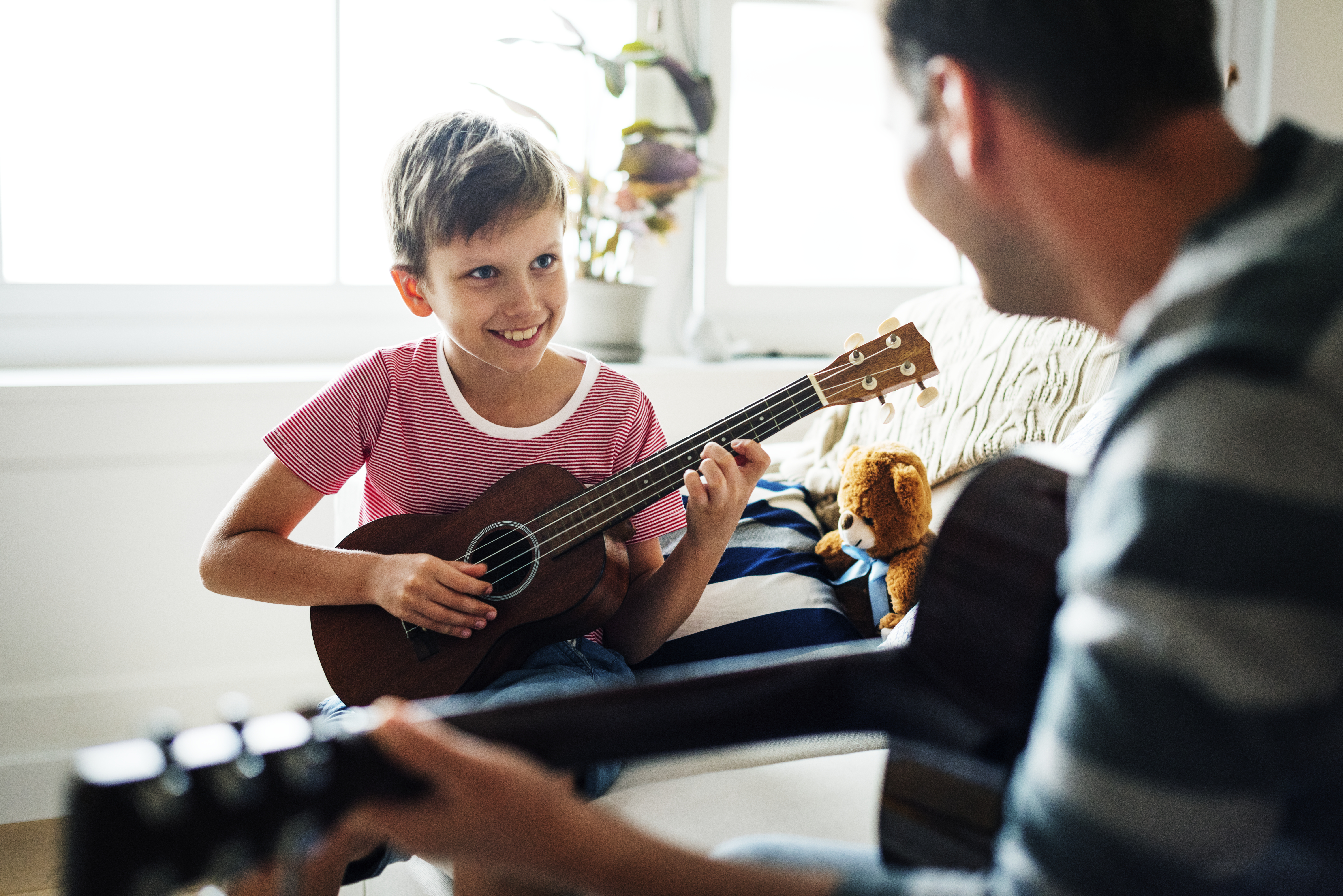 jongen dat op een gitaar leert spelen